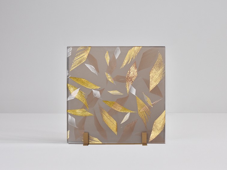 Architectural feather glass. Smoked glass laminated with gold and white feathers.