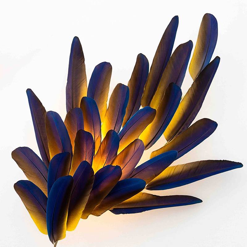 Illuminated feather wall sconce with deep blue & gold hues & ethereal textures by Janaïna Milheiro available through RUNE, New York.