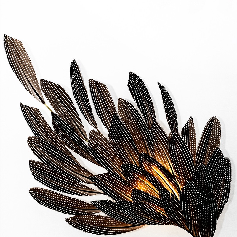Illuminated feather wall sconce illustrates the bespoke lighting design capabilities of Janaïna Milheiro available through RUNE, New York.