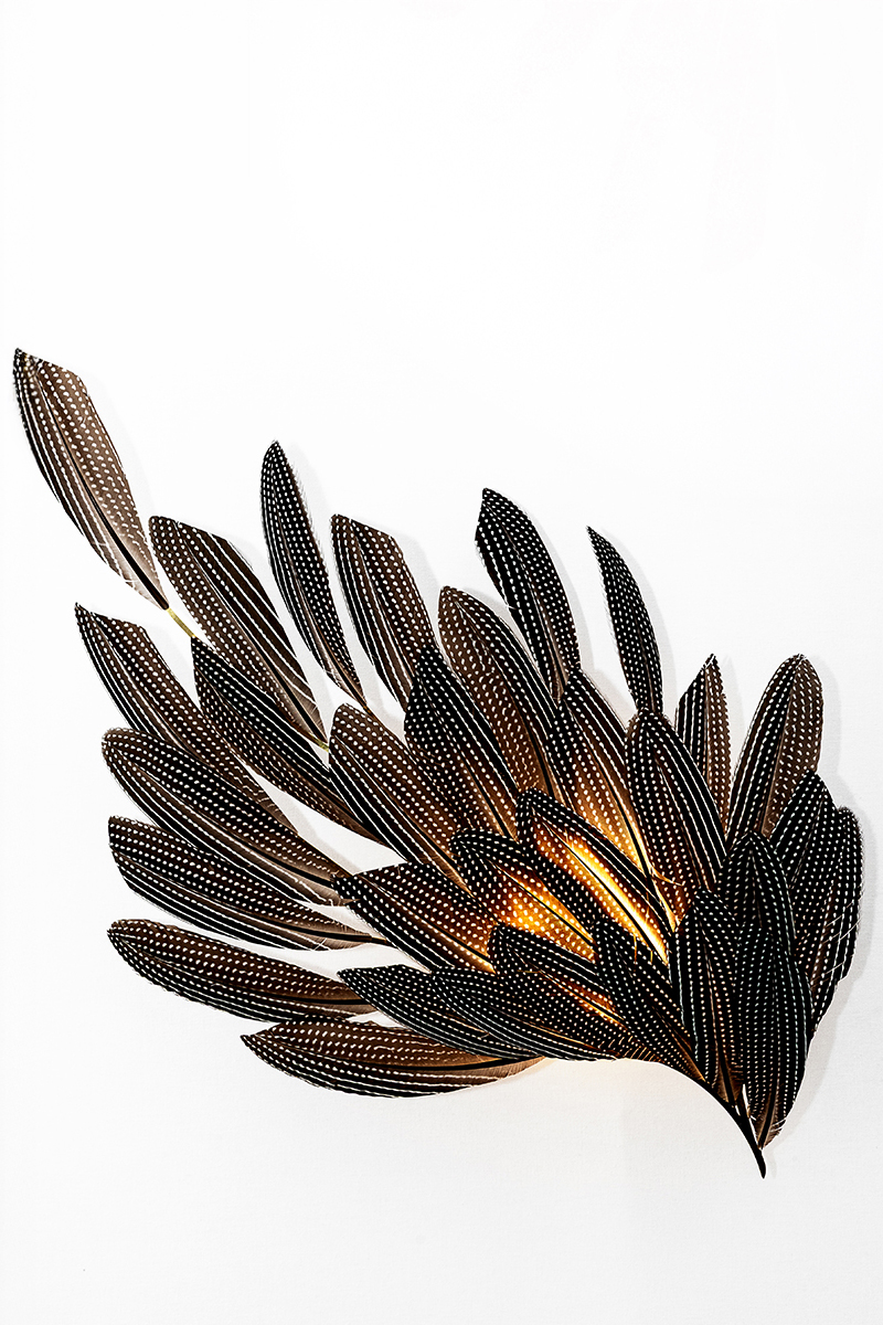 Illuminated feather wall sconce illustrates the bespoke lighting design capabilities of Janaïna Milheiro available through RUNE, New York.