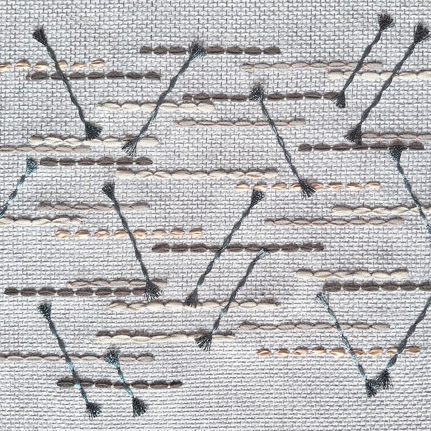 Close-up of geometric hand-stitched embroidery on beautifully textured fabric textile by P+L Studio, showcasing intricate French craftsmanship.